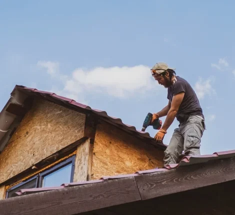 Man fixing a roof with electric drill