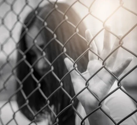 Woman behind a metal fence