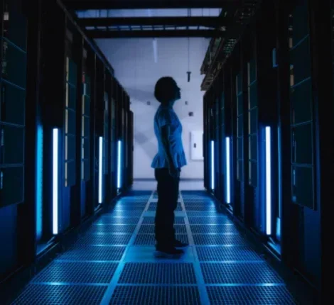 A person standing between super computers