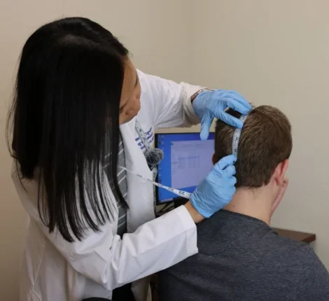 Dr. Aprinda Indahlastari Queen measuring the back of patient's head