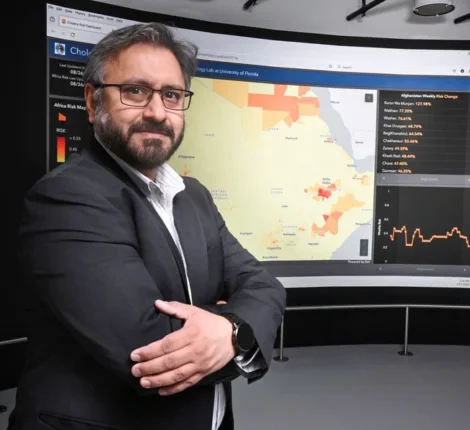 Professor standing in front of board with a map on it.